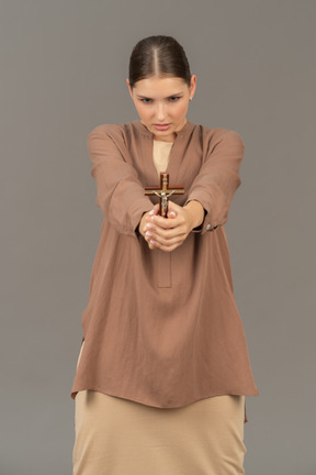 Christian lady holds a cross with both hands