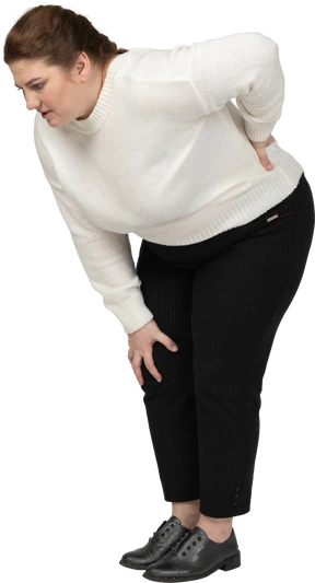 Plump woman in casual clothes suffering from pain in lower back