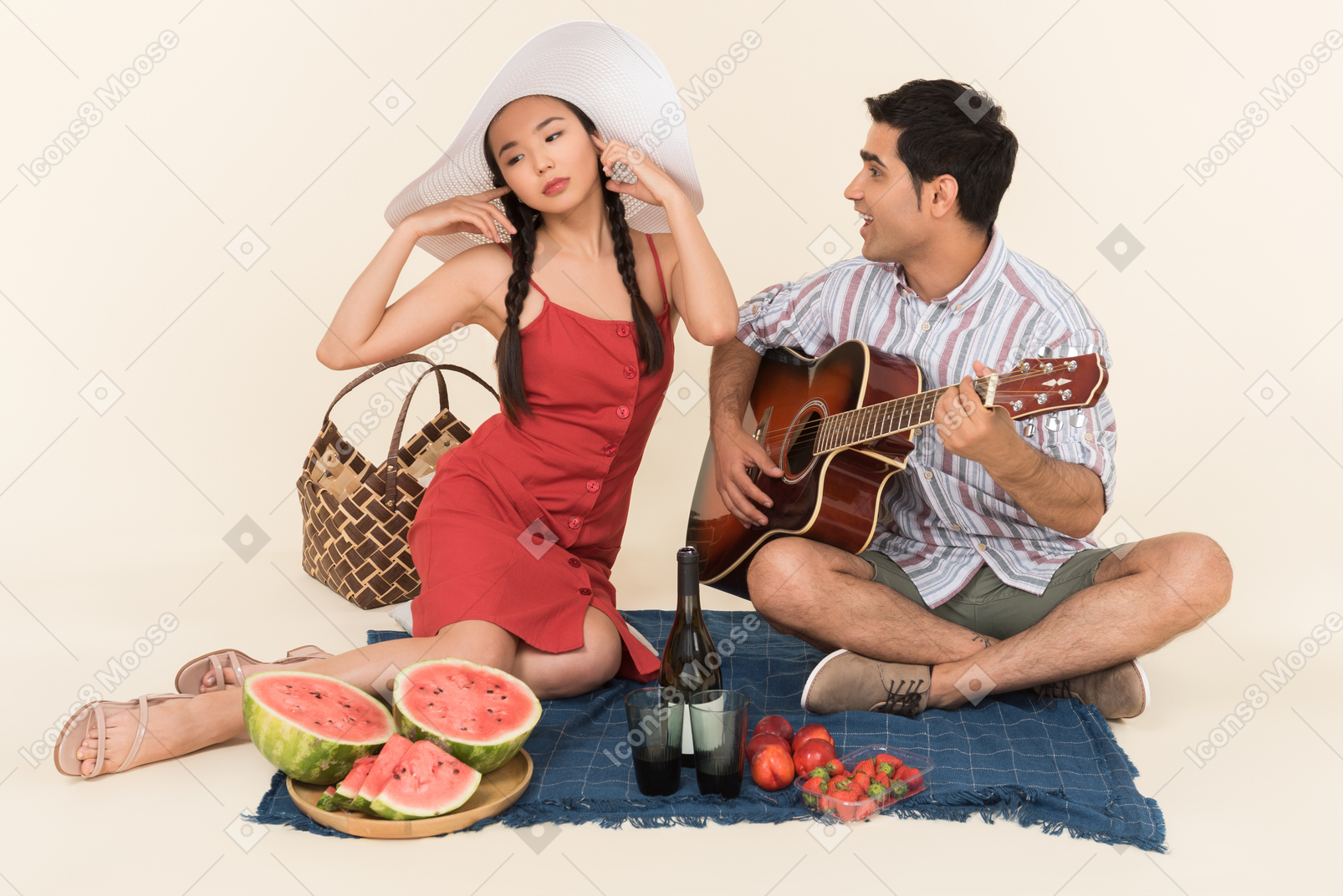 Interracial couple having picnic and man playing on guitar