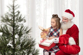 Santa claus presentando regalos de navidad a una niña