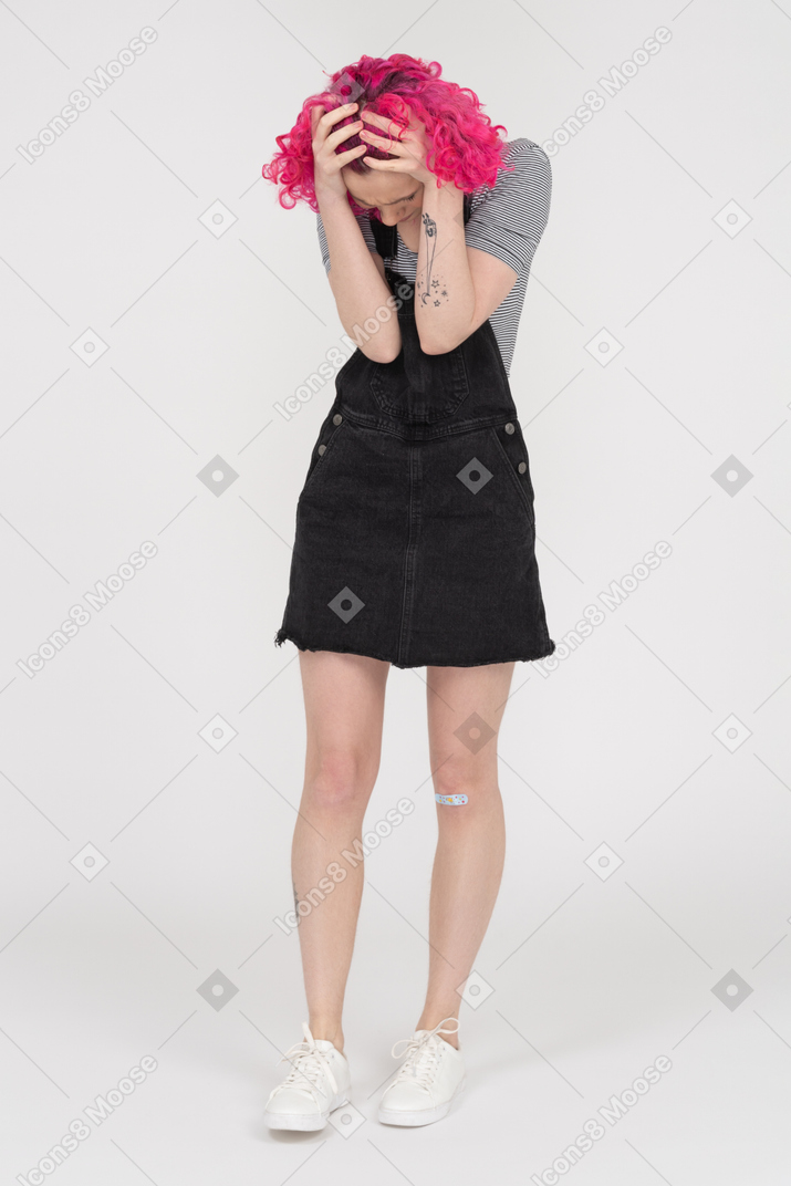 Full length portrait of an unrecognizable woman holding her head