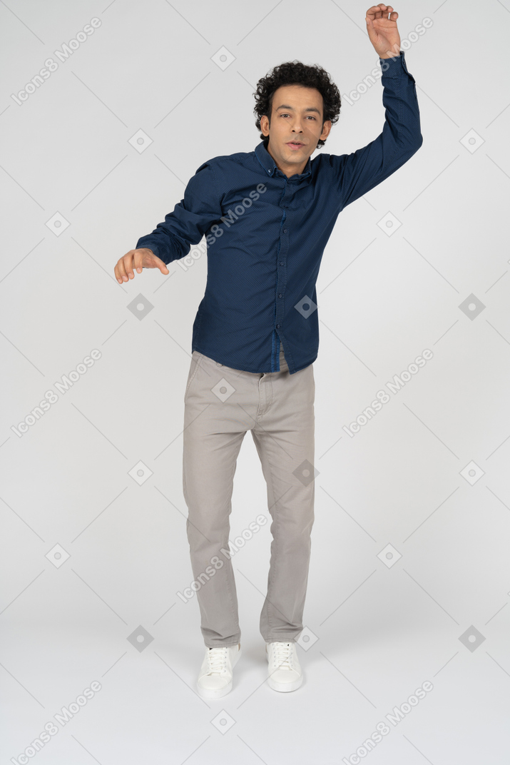 腕を上げて立っているカジュアルな服装の男性の正面図