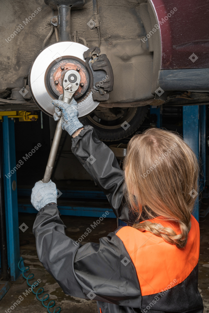 Young woman repairing car