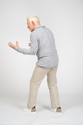 Back view of a man standing and showing size with hands