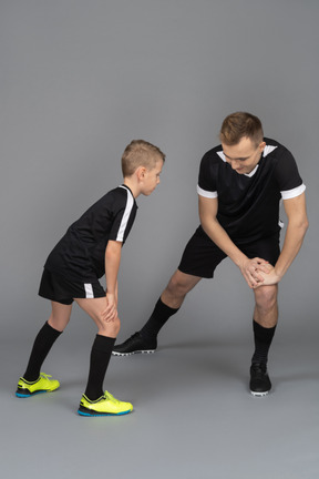 Full-length of a young man coaching little boy making a lunge