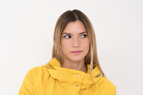 Chica en un impermeable amarillo mirando a un lado