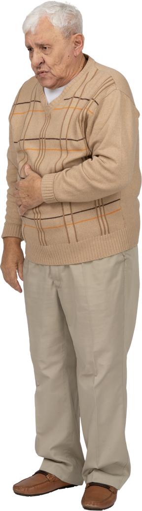 Vista frontal de un anciano con ropa informal que sufre de dolor de estómago