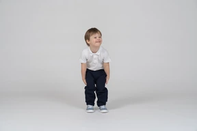 Cheerful boy leaning forward and looking aside