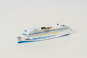 The toy cruise ship on the light grey background