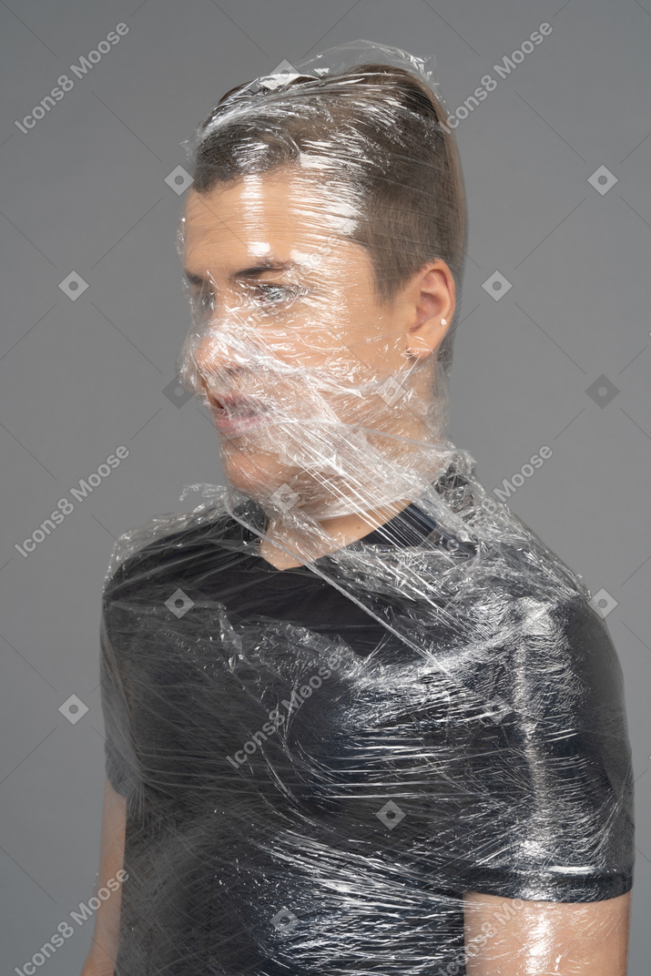 Gros plan d'un jeune homme enveloppé dans du plastique