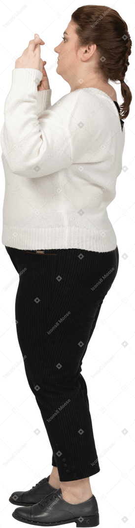 Vista laterale di una donna grassoccia in abiti casual che incrociano le dita