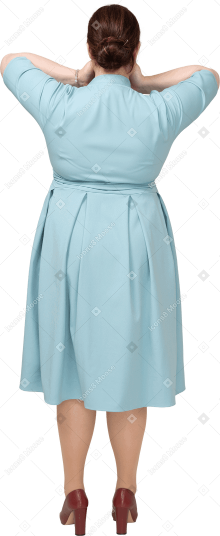 Rear view of a woman in blue dress covering mouth with hands
