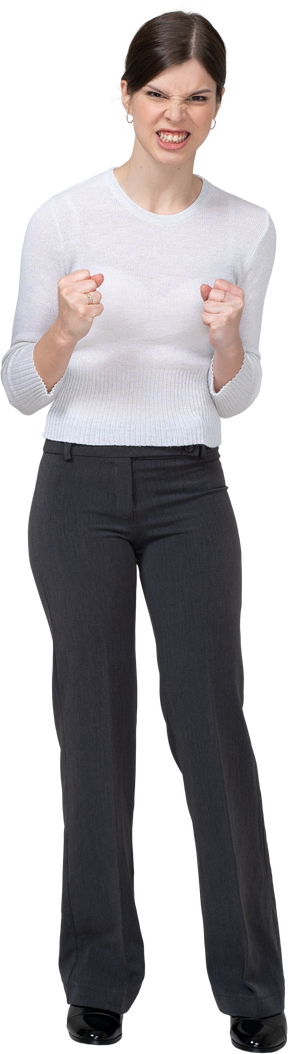 Front view of a furious woman in office clothing clenching fists