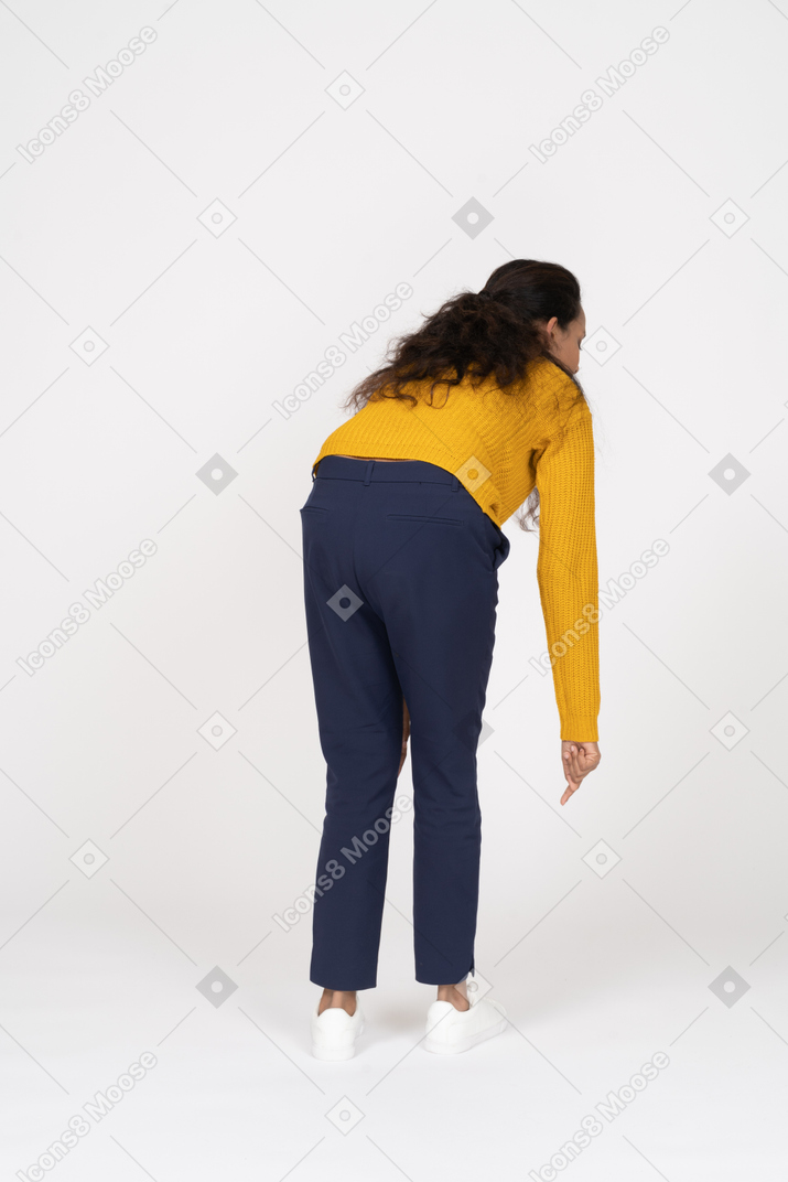 Rear view of a girl in casual clothes bending down