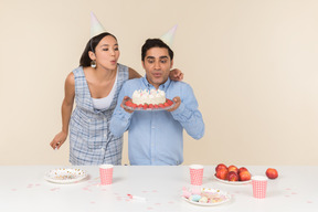 Joven pareja interracial celebrando el cumpleaños del hombre