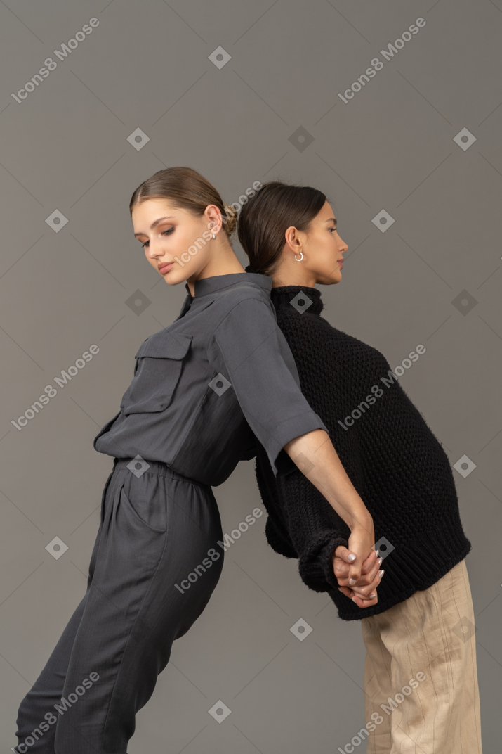 Dos mujeres de pie espalda con espalda