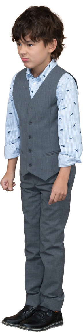Vista frontale di un ragazzo carino in abito grigio che fa smorfie
