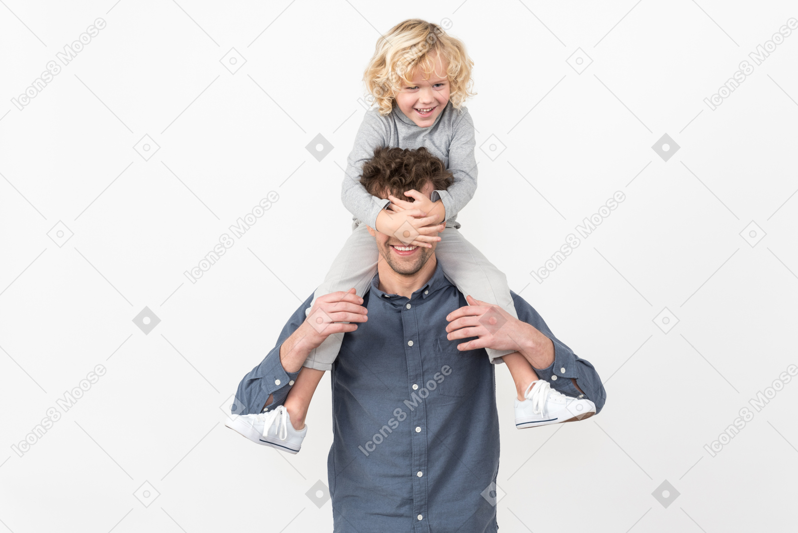 Kid boy sitting on on his father's neck and covering his eyes