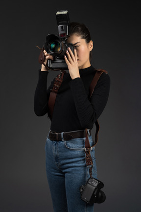 Jeune femme photographe étant enveloppé dans le travail