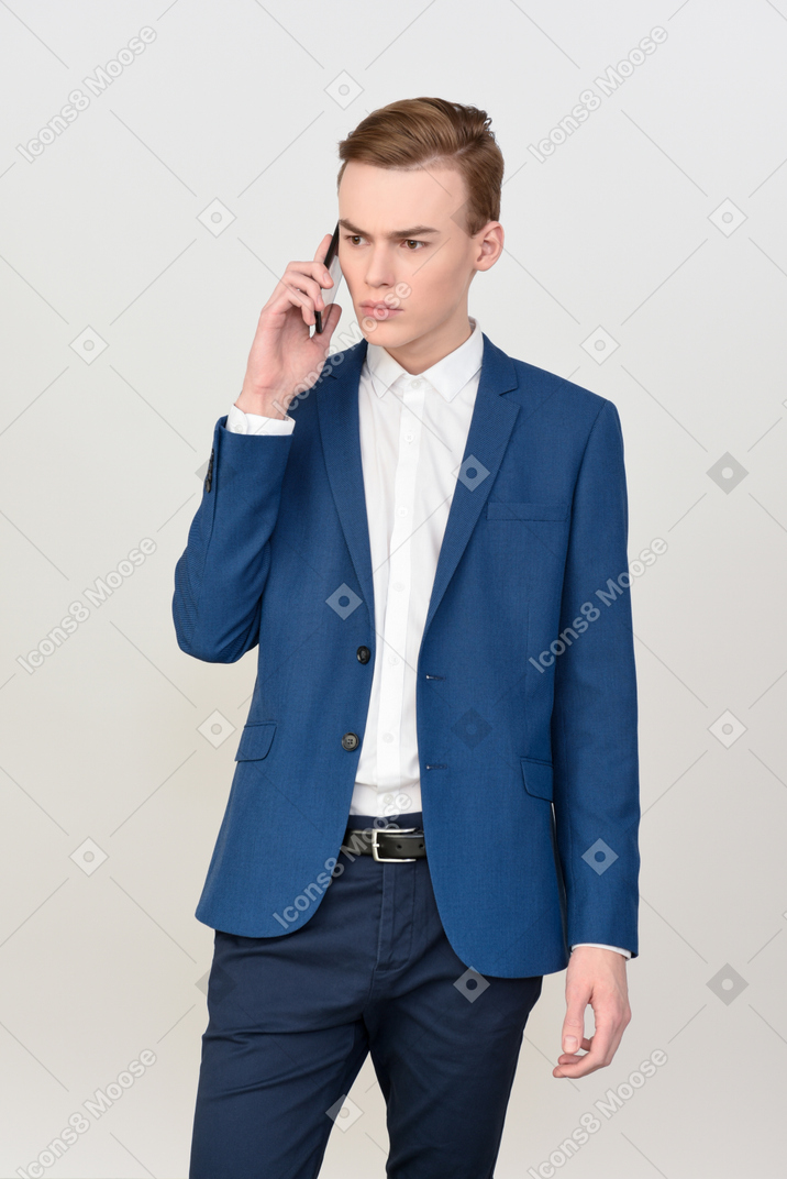 Beau jeune homme parlant au téléphone