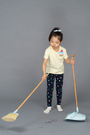 Little girl sweeping the floor