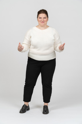 Mulher gordinha feliz com suéter branco fazendo caretas