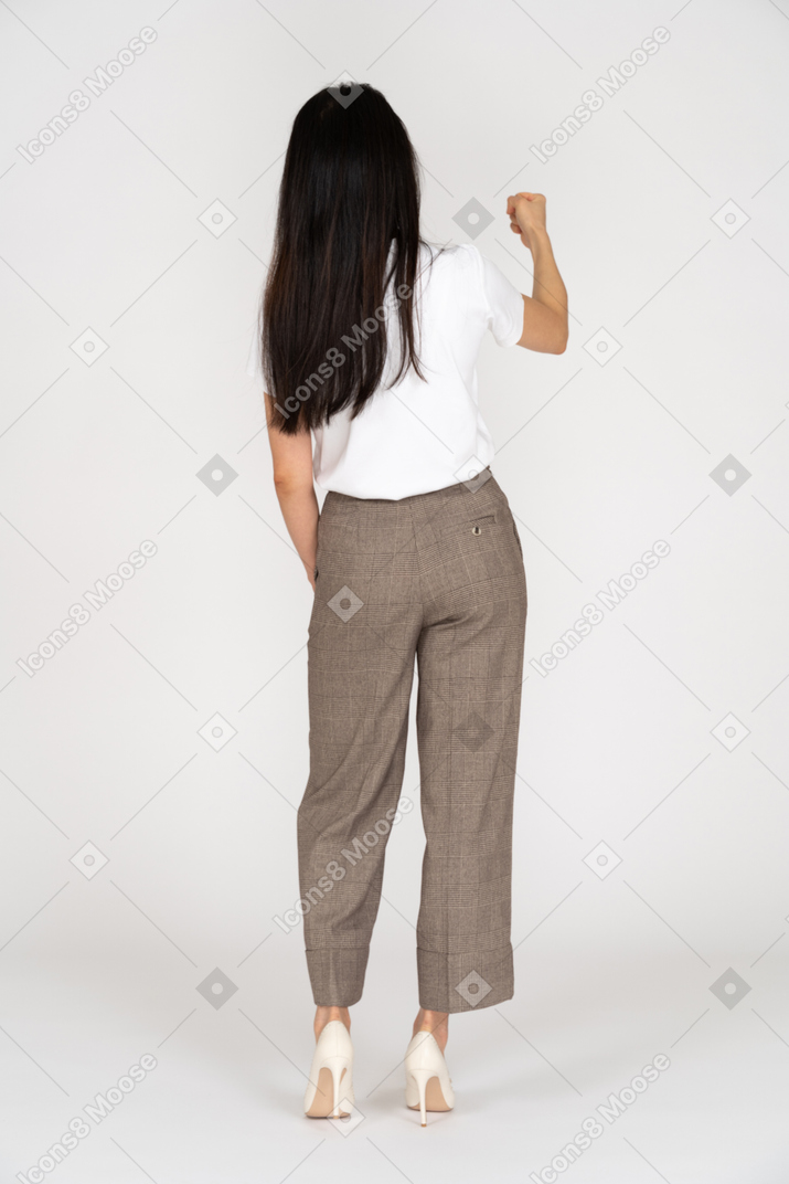 Back view of a young woman in breeches clenching fist