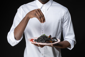 Chef che modifica i dettagli finali prima di servire la pasta