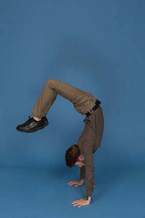 Slim young man doing gymnastic exercises