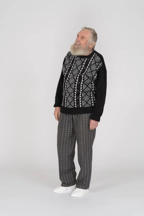 Front view of an elderly man standing and looking up