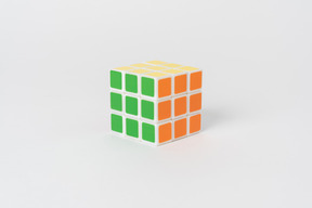 Un cubo di rubik risolto puzzle che giace su un semplice sfondo bianco