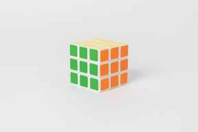 A solved rubik's cube puzzle lying against a plain white background