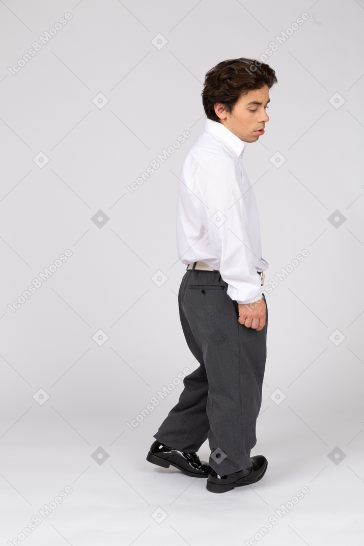Вид сбоку задумчивого молодого человека в деловой повседневной одежде