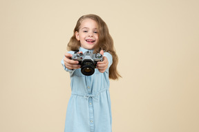 Cute little girl holding a camera