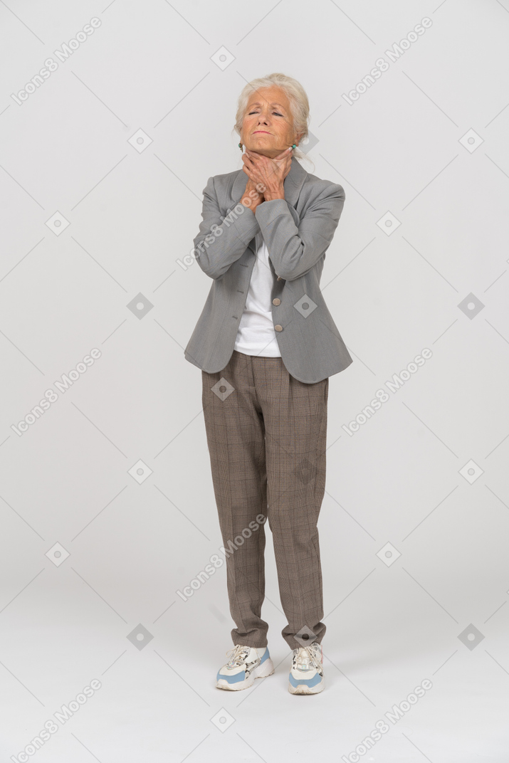 一位身着西装的老妇人的前视图窒息着自己