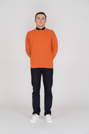 Young man in orange sweatshirt standing