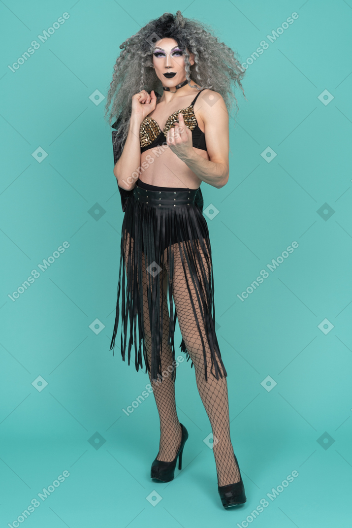 Drag queen in studded bra beckoning with finger