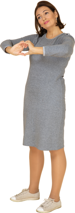一个穿着灰色裙子的女人的前视图，显示出心脏的手势