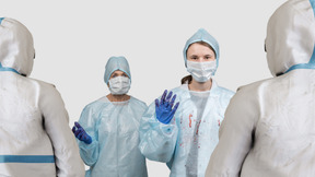Surgeons standing in front of people in protective suits