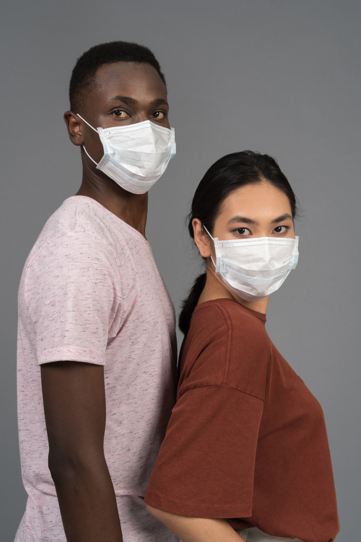 A young couple wearing face masks