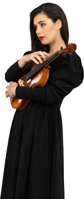 Vista de três quartos de uma jovem de vestido preto segurando o violino