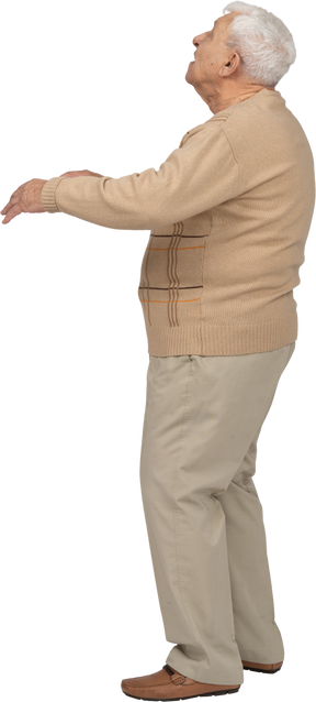 Vue latérale d'un vieil homme en vêtements décontractés debout avec les bras tendus