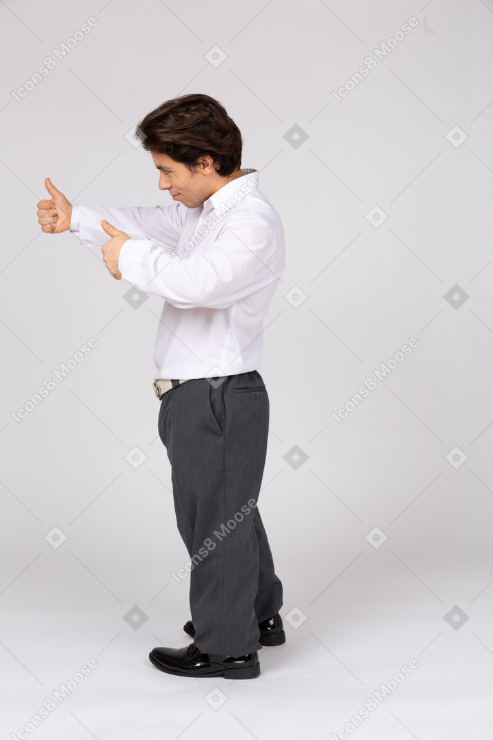 Вид сбоку на мужчину в формальной одежде, показывающего большой палец вверх