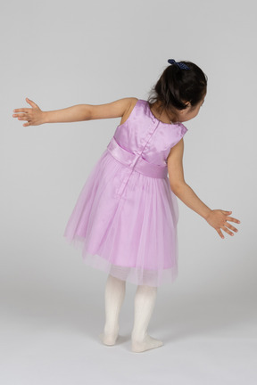 Girl in pink dress falling backwards