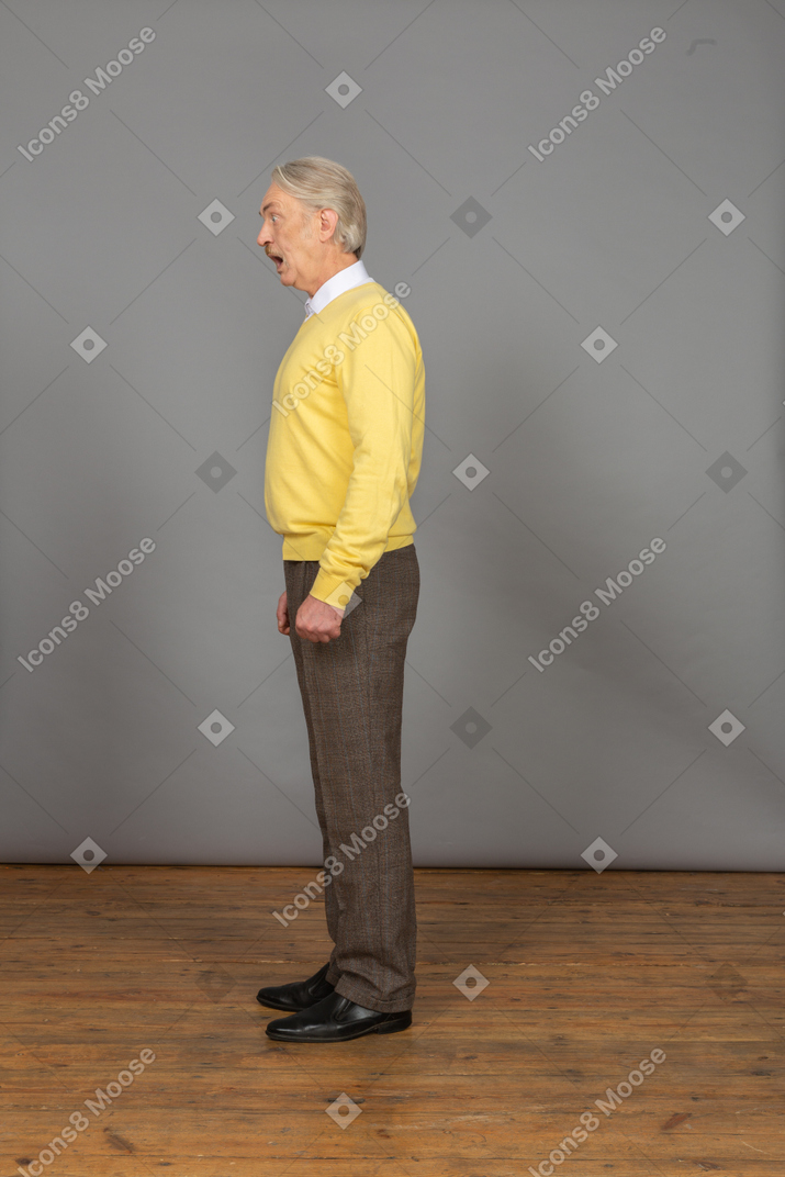 Side view of a talking man in a yellow pullover
