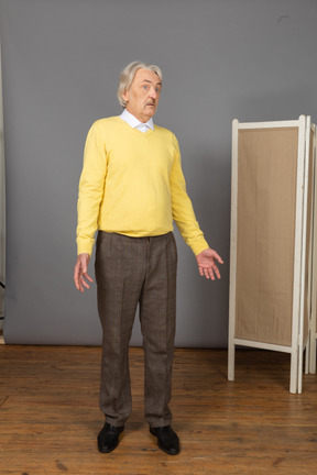 Front view of a questioning old man turning his head