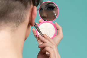 Back view of a person putting on eyeshadow