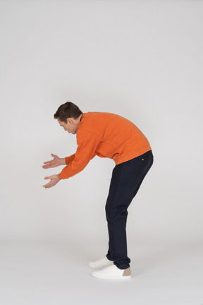 Young man in orange sweatshirt standing