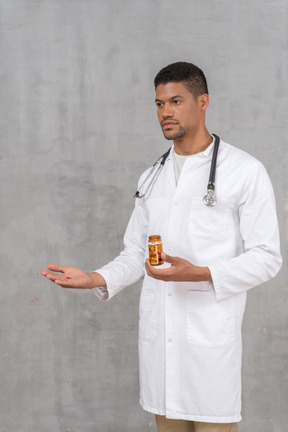 Young doctor offering a pill