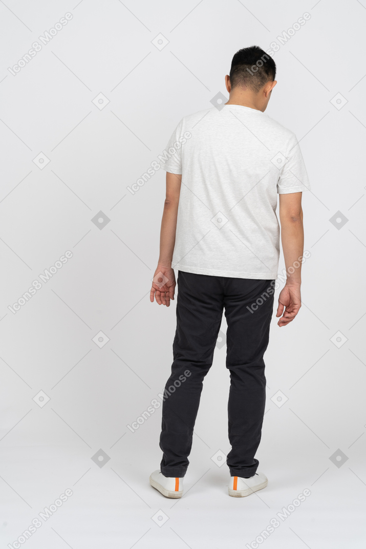 Man in casual clothes standing back to camera and looking down